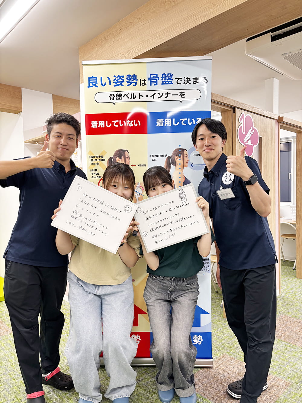 施術後の感想パネルを手にした患者が、制服姿のスタッフと笑顔で記念撮影している様子