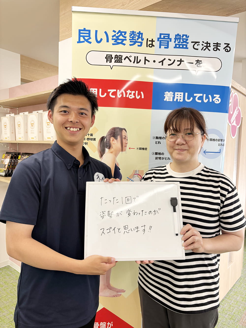 施術後の感想パネルを手にした患者が、制服姿のスタッフと笑顔で記念撮影している様子