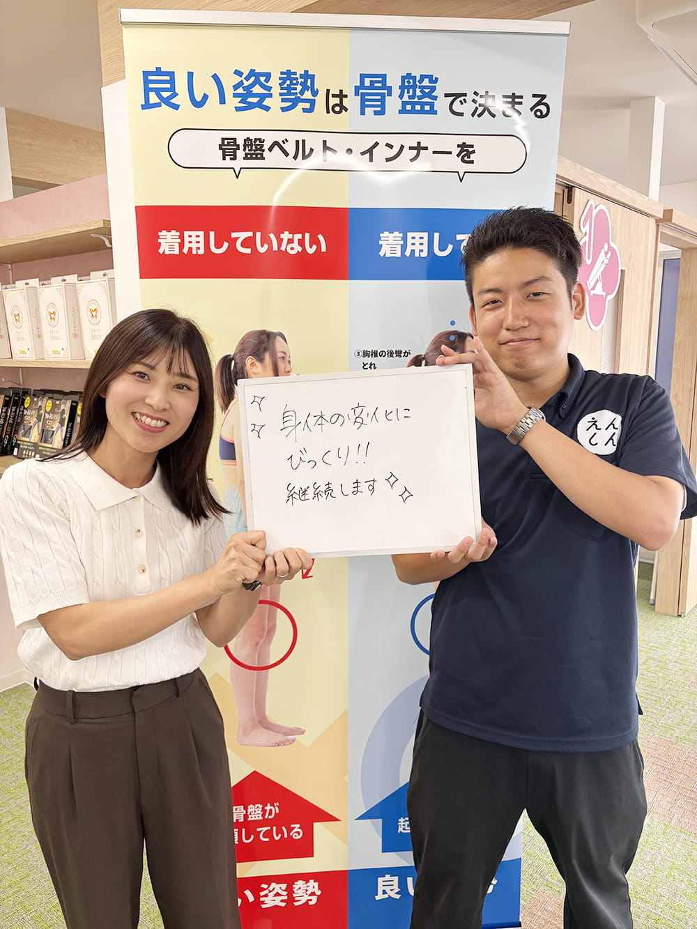 施術後の感想パネルを手にした患者が、制服姿のスタッフと笑顔で記念撮影している様子