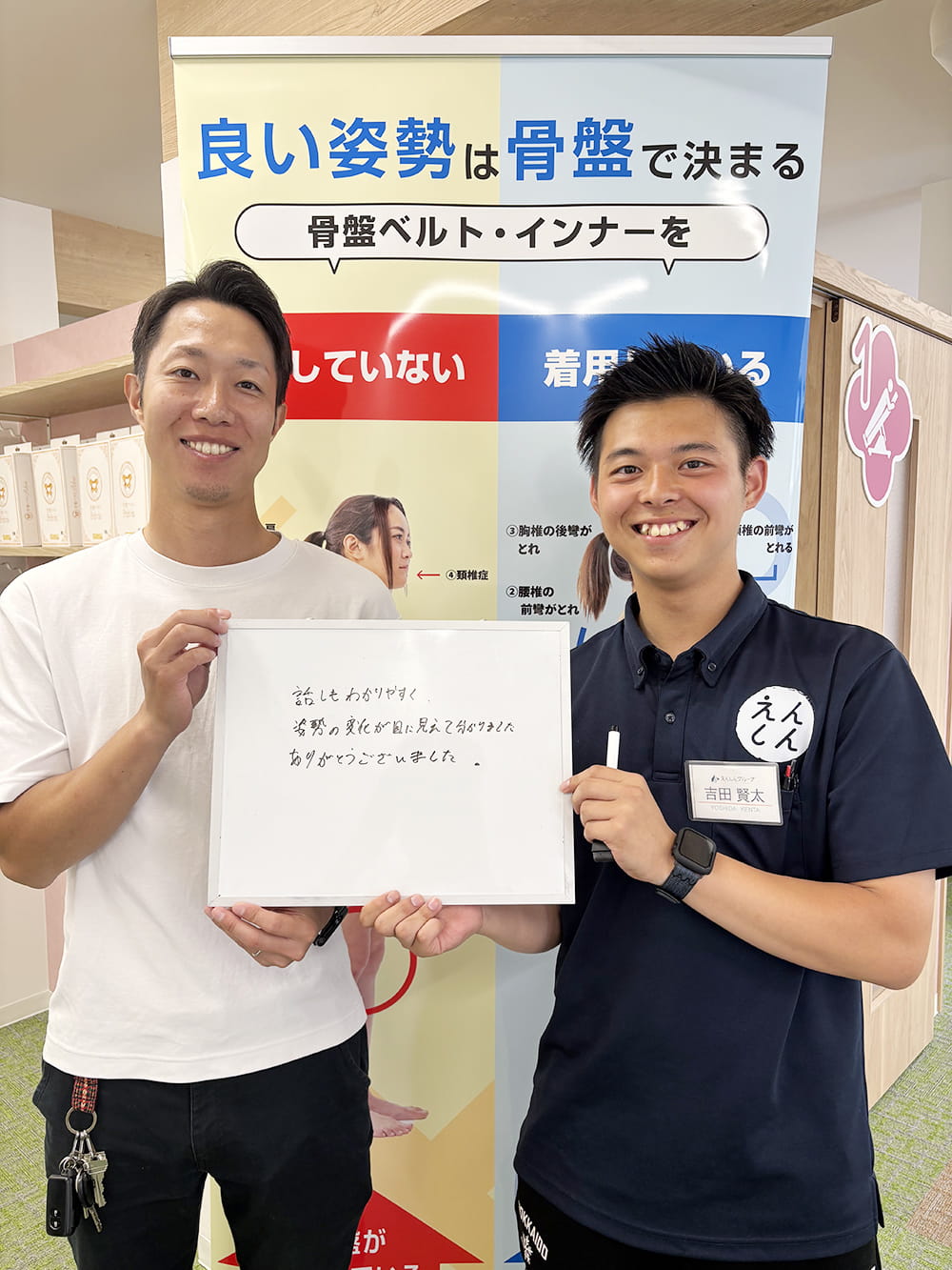 施術後の感想パネルを手にした患者が、制服姿のスタッフと笑顔で記念撮影している様子