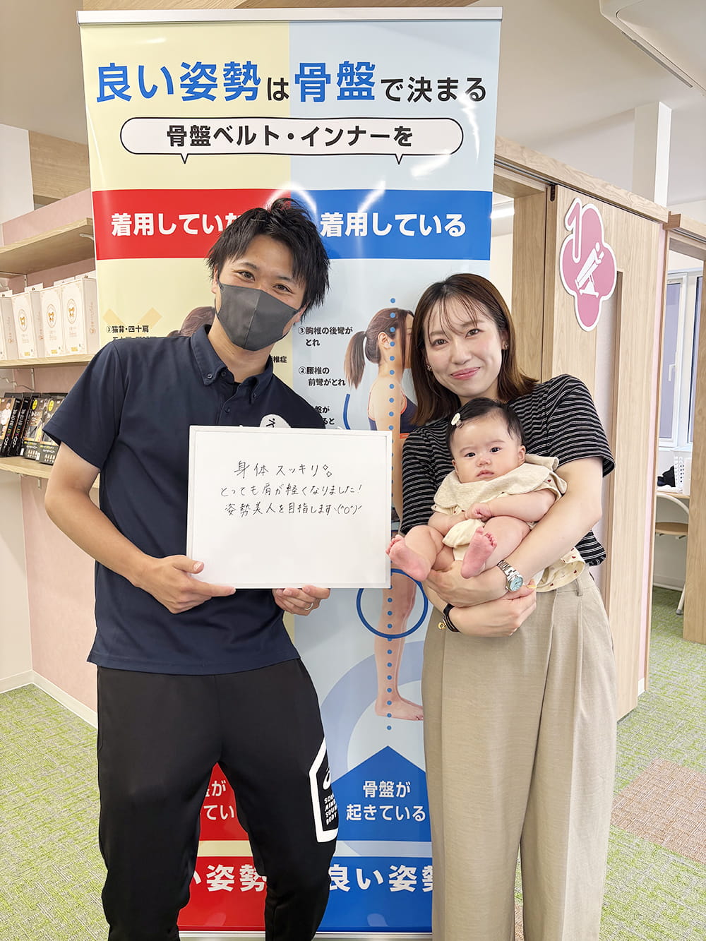 施術後の感想パネルを手にした患者が、制服姿のスタッフと笑顔で記念撮影している様子